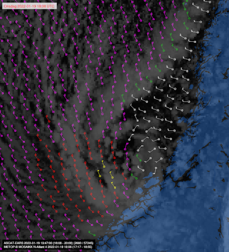 Satellittmålt vind fra et s.k. scatterometer (ASCAT) plottet på et satellittbilde viser typisk fordeling av vinden rundt et polart lavtrykk. Den kraftigste vinden er markert med gul farge, og angir her nordlig full storm vest for lavtrykkssenteret.