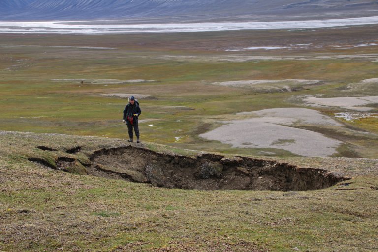 Et stort synkehull i tundraen viser seg i et ellers uberørt landskap.