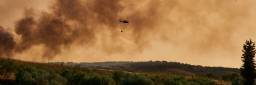 Huelva, Bonares, Spain; August 05 2023: Infoca helicopter, Firefighters, prepares the trajectory to pour water on the forest fire. 1