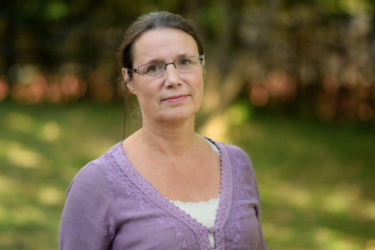 Inger Hanssen-Bauer med brunt hår i hestehale og grønn natur i bakgrunn.