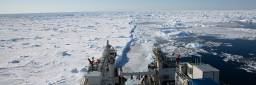 Forskningsskipet FF Kronprins Haakon kjører gjennom Framstredet der store deler havet er dekket av is. Blå himmel skimtes i horisonten.