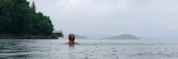 Kvinne svømmer i regnvær
