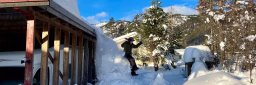 Jente hopper fra hyttetak med mye snø.
