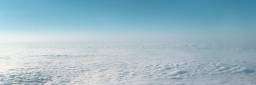 Bilde tatt fra fly, av skyer og blå himmel